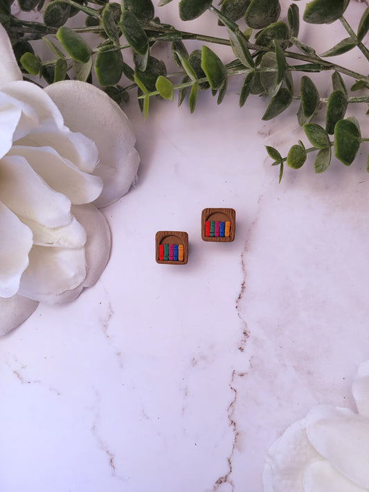 Bookshelf stud made of polymer clay sits on a marble background surrounded by foliage.