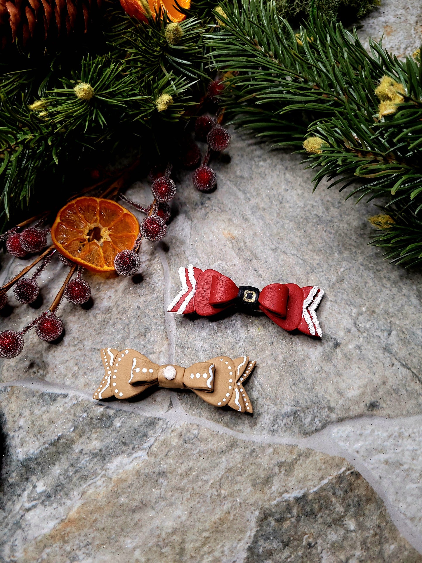 Christmas Bow Barrettes on a stone background surrounded by foliage