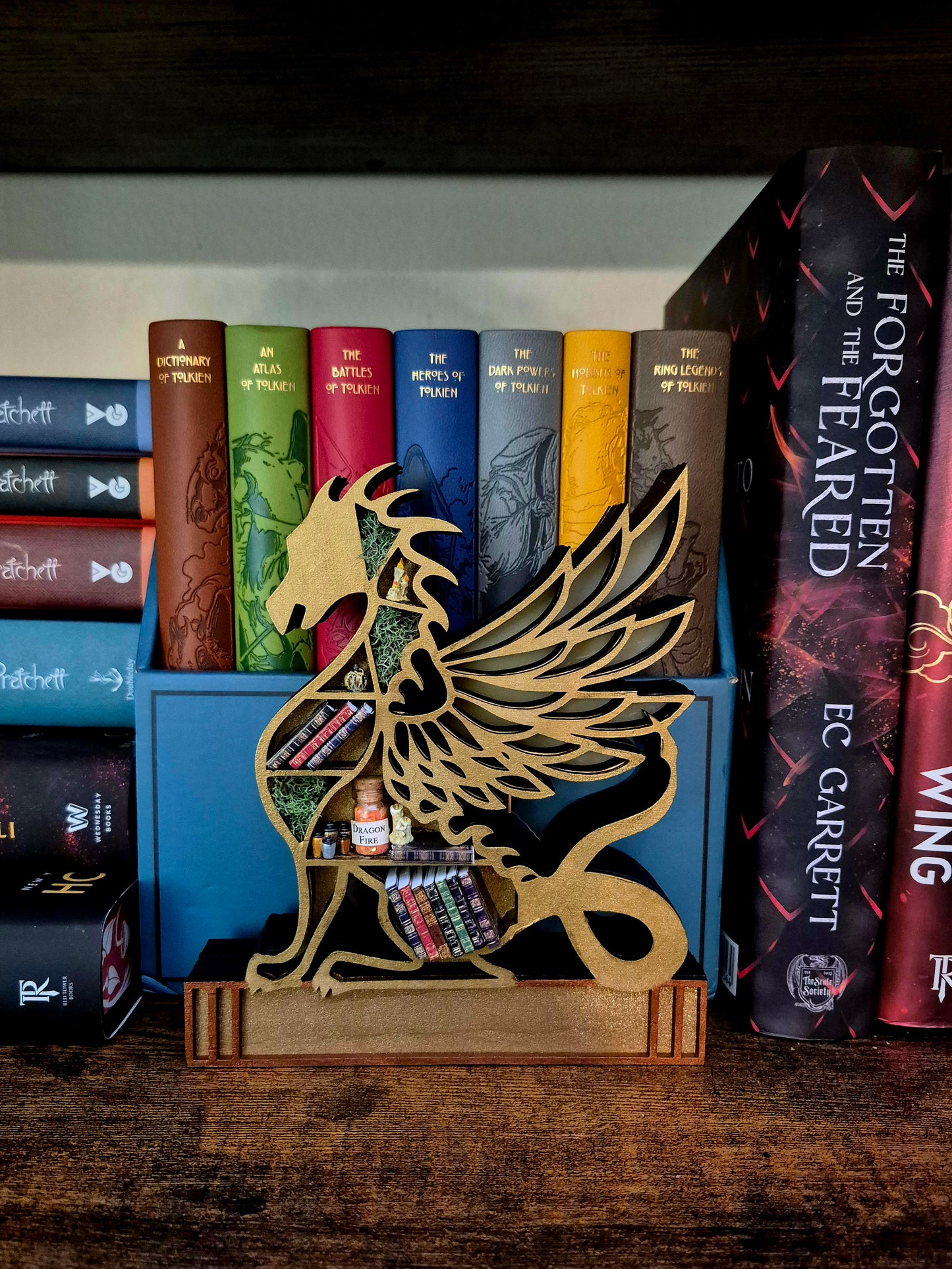 Gold dragon mini bookcase in front of books.