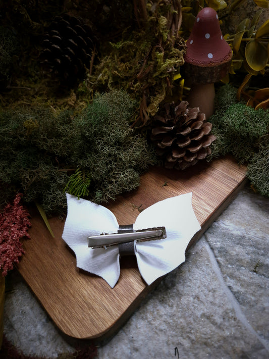 back of Halloween stripe bat bow on a wood and stone background