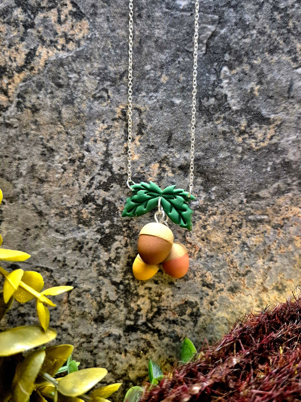 Acorn Necklace on a stone background surrounded by foliage