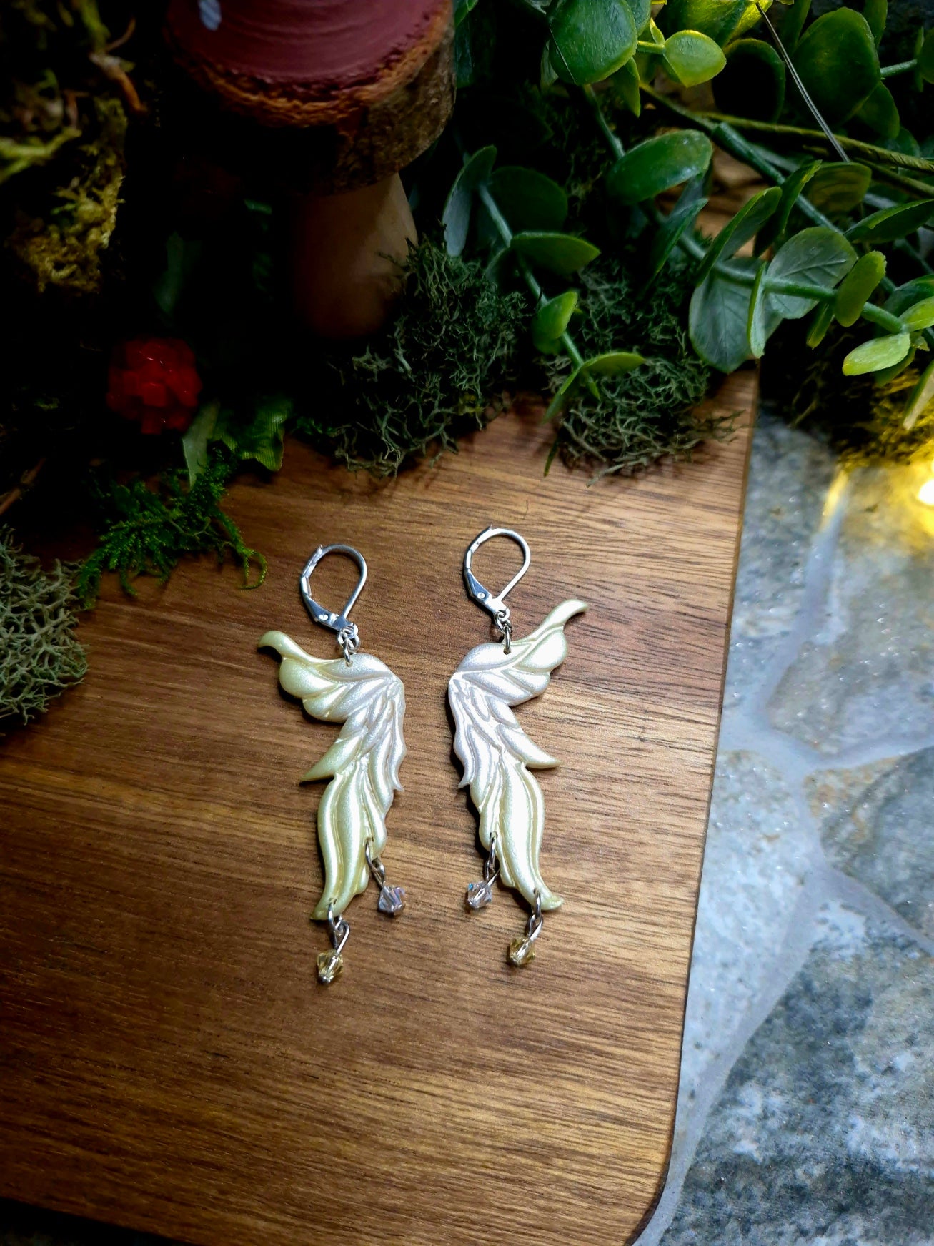 yellow fairy wing earrings on a wood and stone background