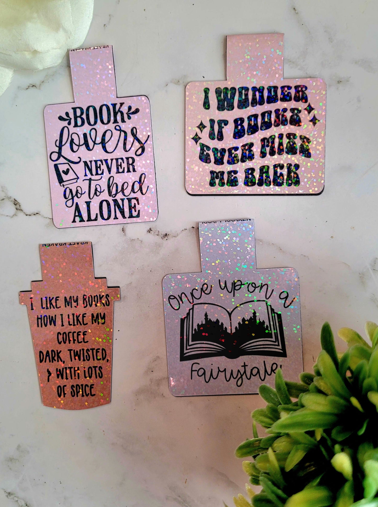 Book lovers, miss me, coffee, fairytale bookmarks on a marble background surrounded by foliage.