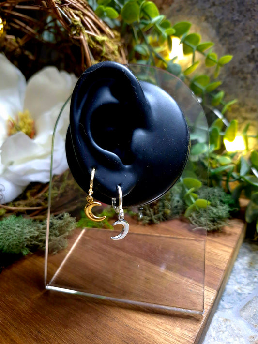 gold and silver moon charm earrings on display ear