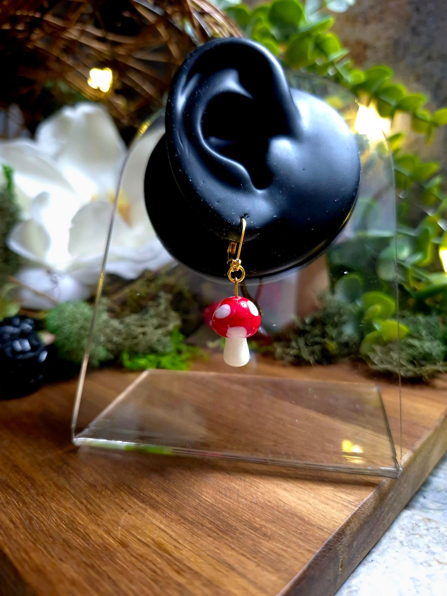 Gold Toadstool Charm Earring on a display ear