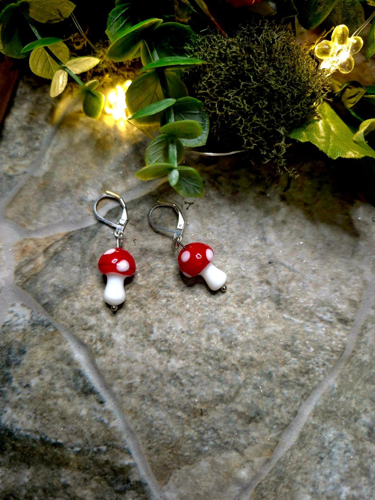 Silver Toadstool Charm Earrings on a stone background