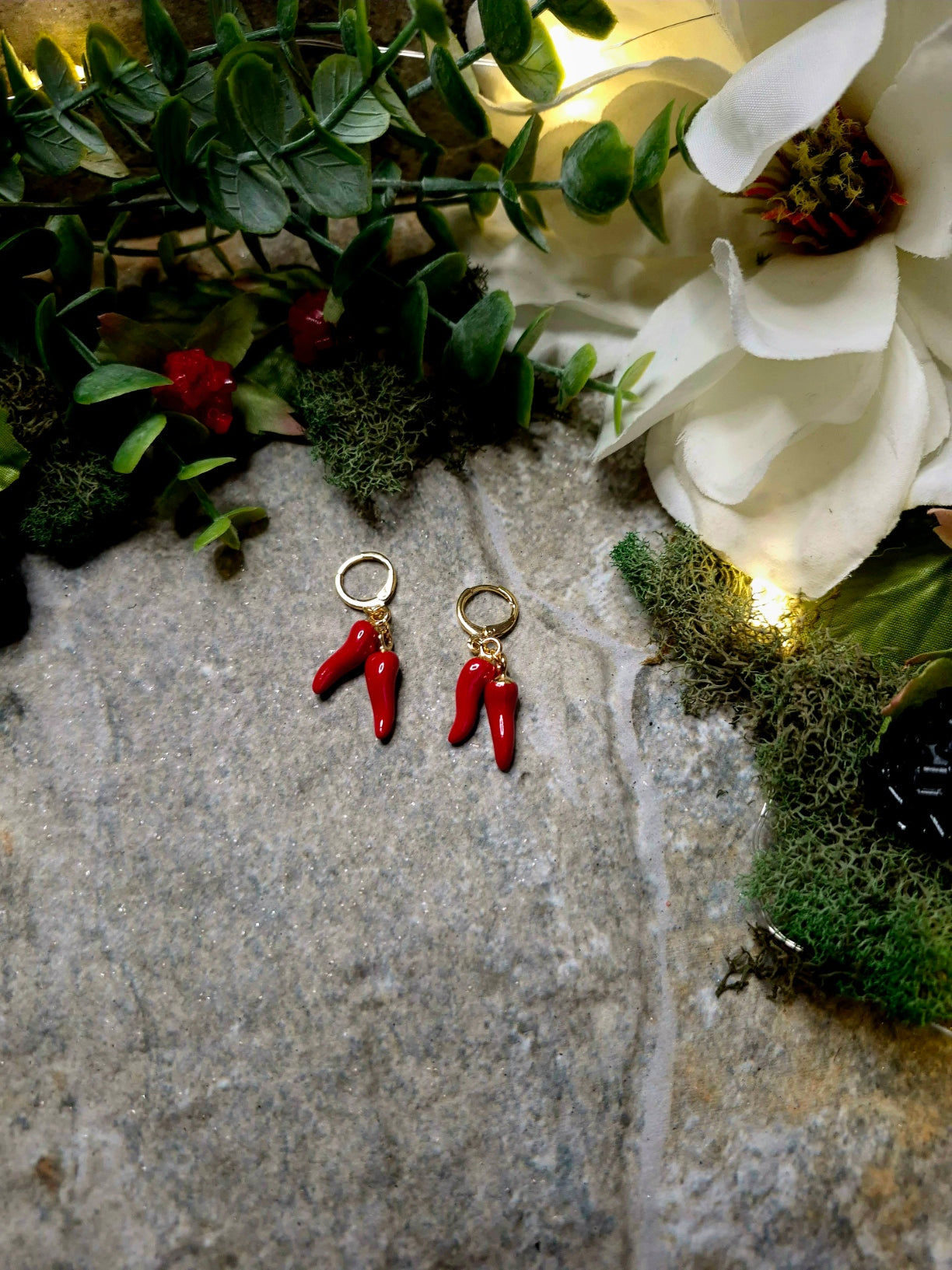 2spice earring on a stone background surrounded by foliage