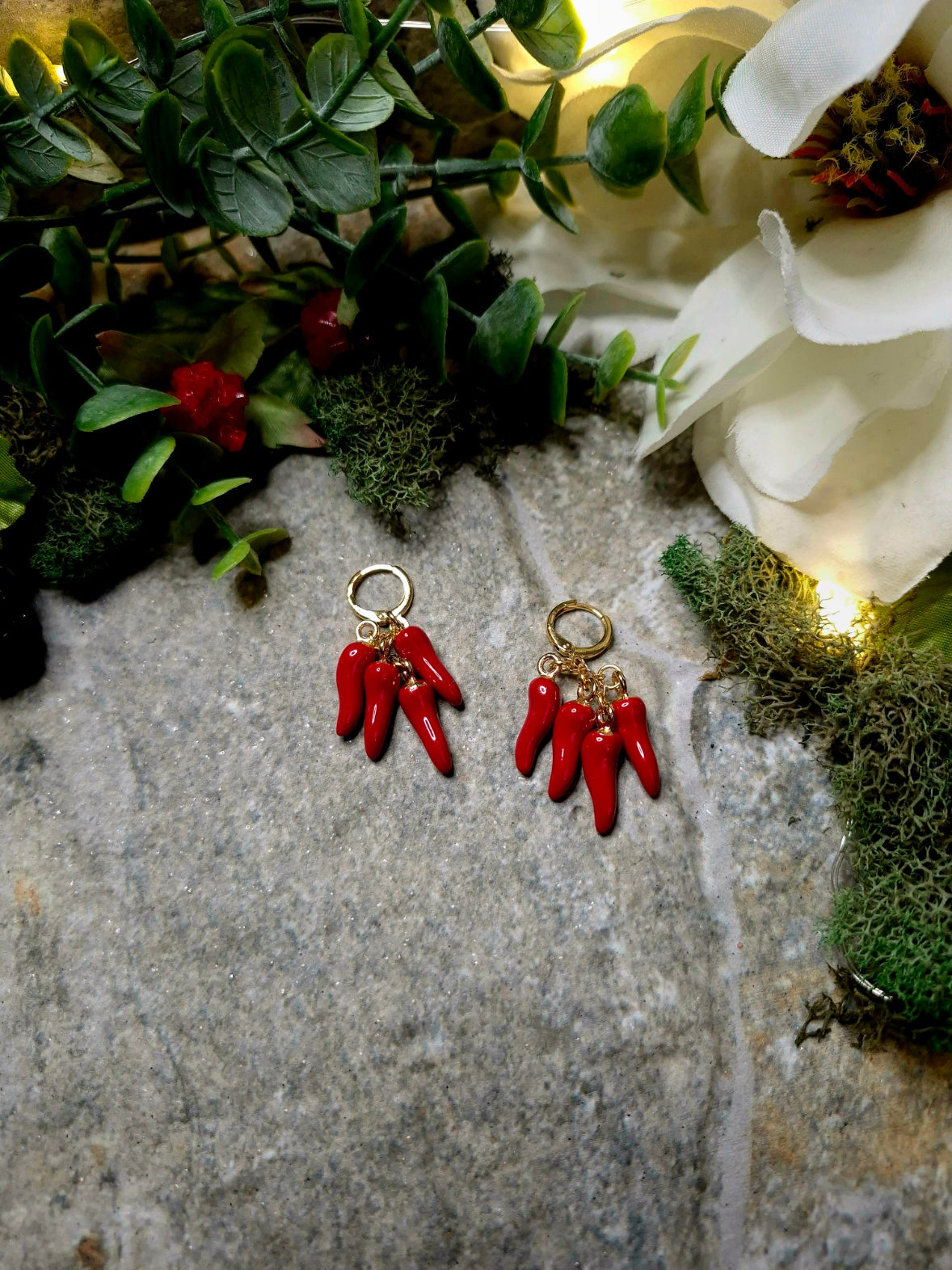 4 spice earring on a stone background surrounded by foliage