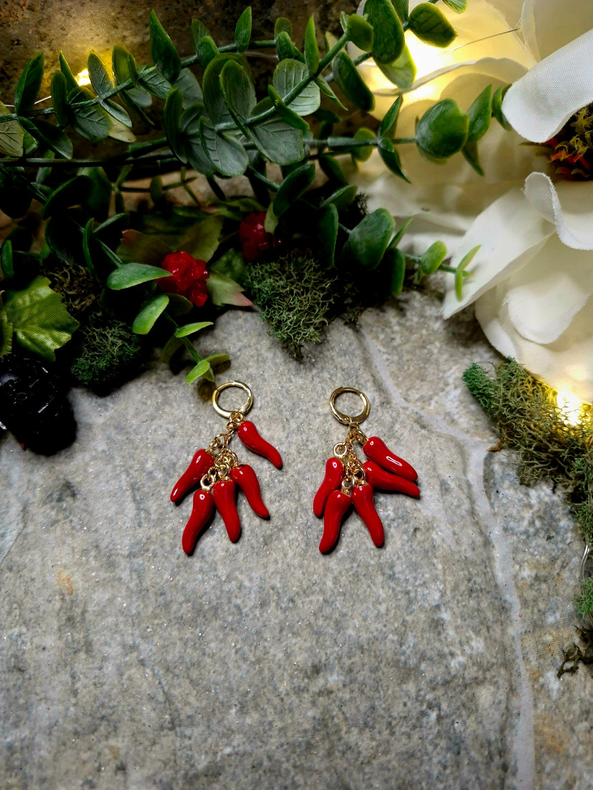 5 spice earring on a stone background surrounded by foliage