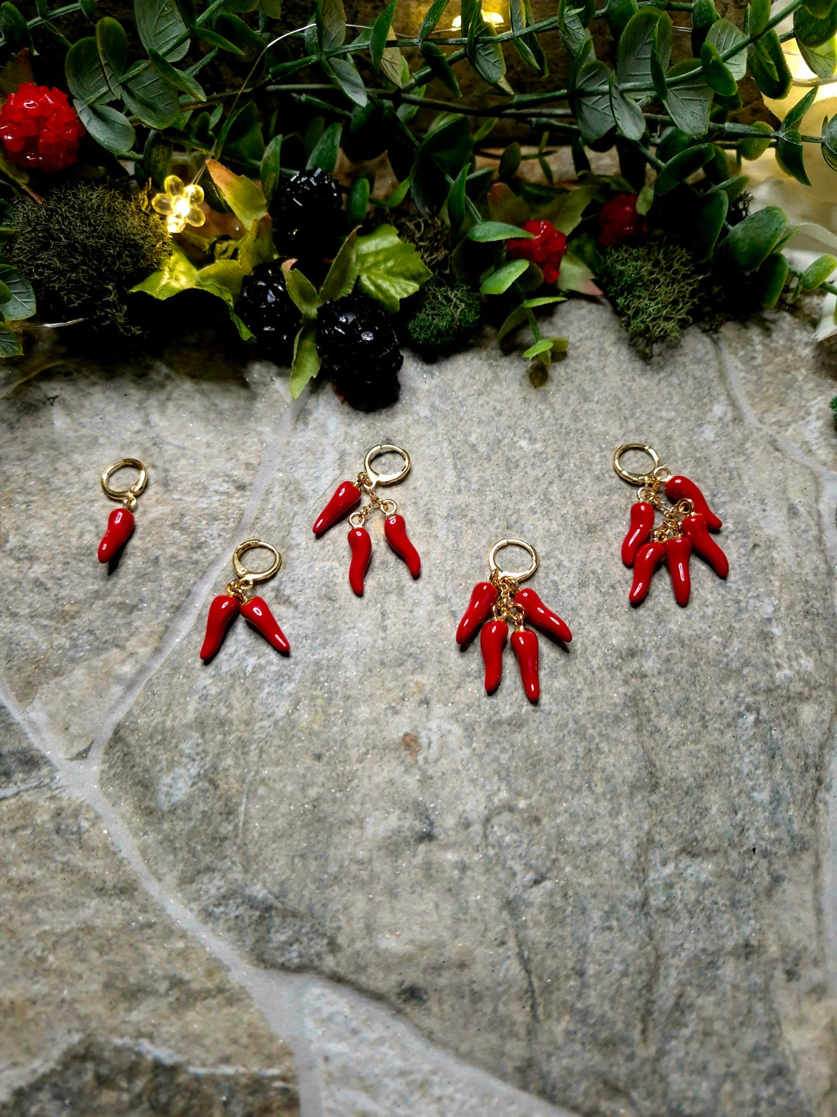 Pepper variation earrings on a stone background surrounded by foliage