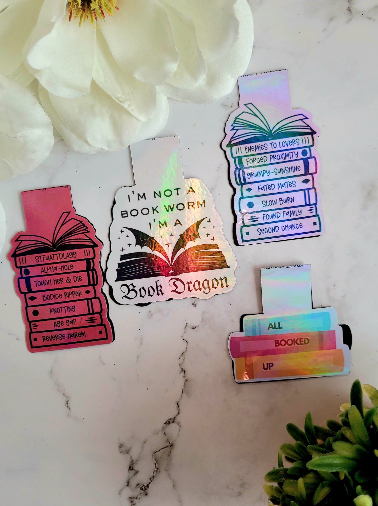 Book Dragon, Tropes, Kinks, All Booked Up, bookmarks on a marble background surrounded by foliage.