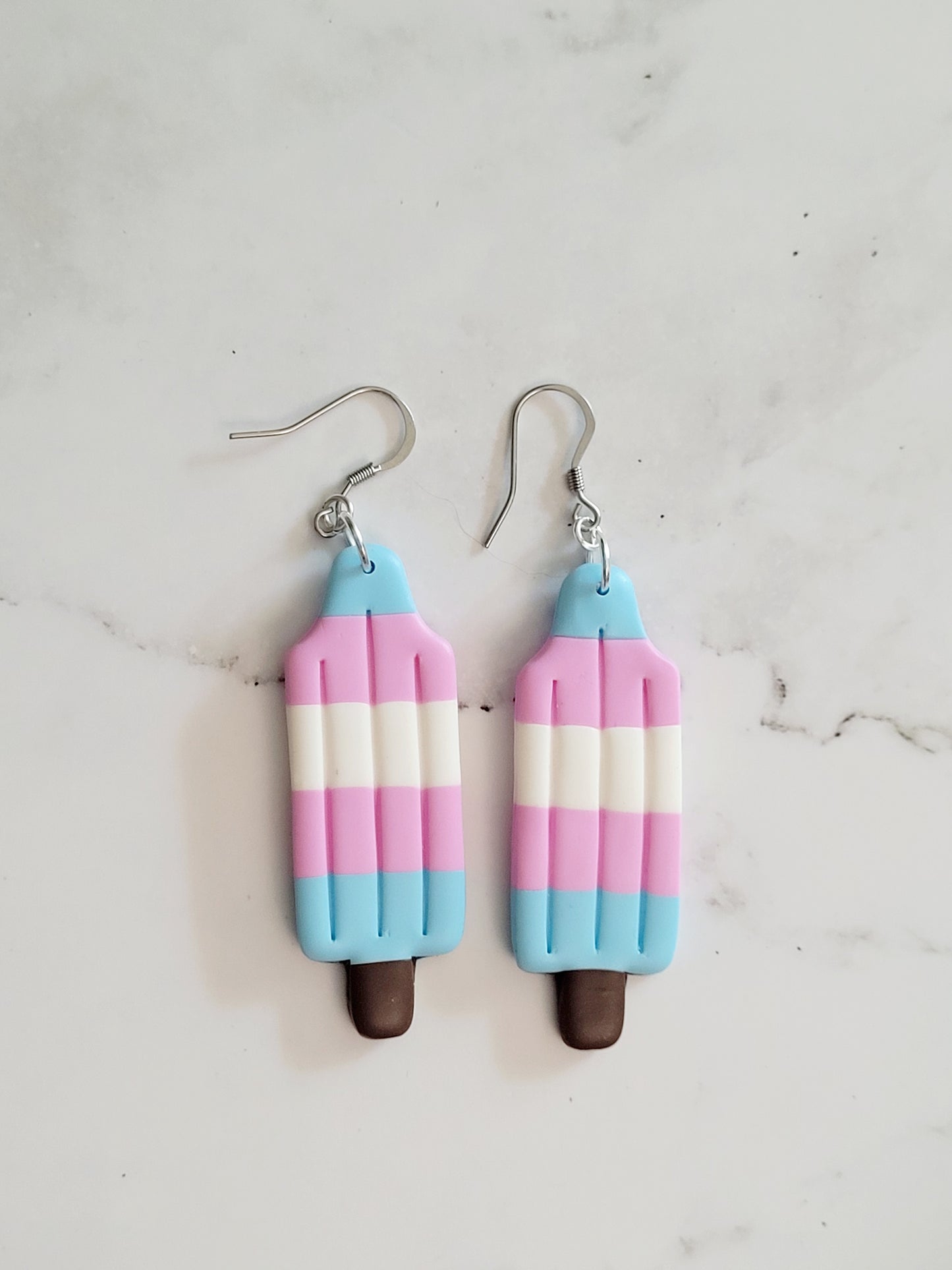 Closeup of the Trans Pride Flag Bomb Pop Earrings