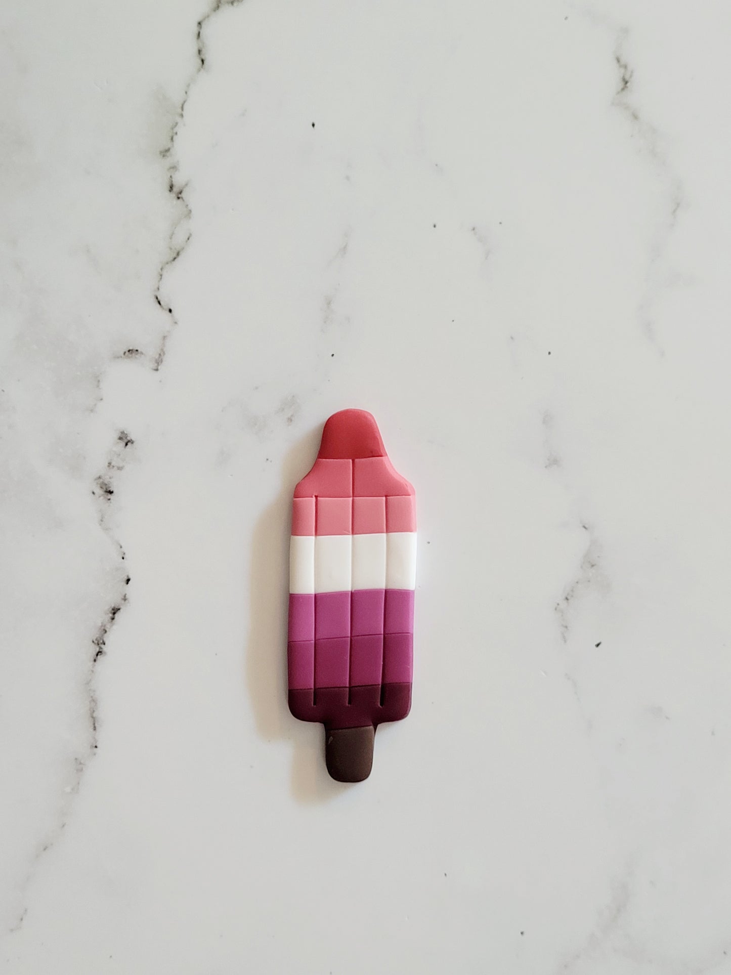 Closeup of the Lesbian Pride Flag Bomb Pop Pin