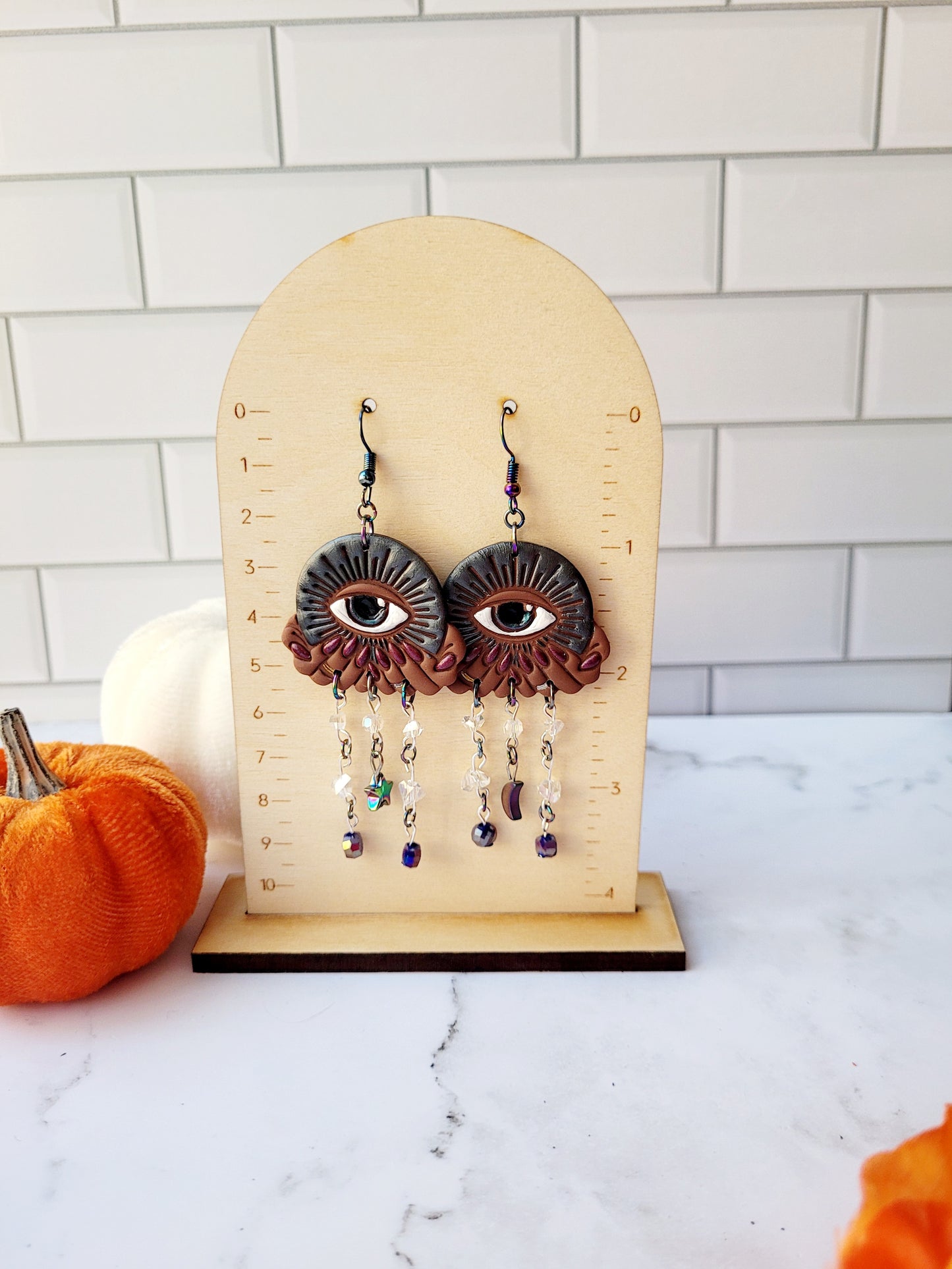 All seeing eye earrings on a ruler