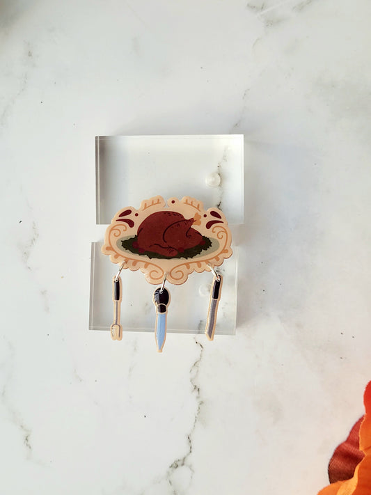 close up of cooked turkey with utensil charm brooch on a marble background.