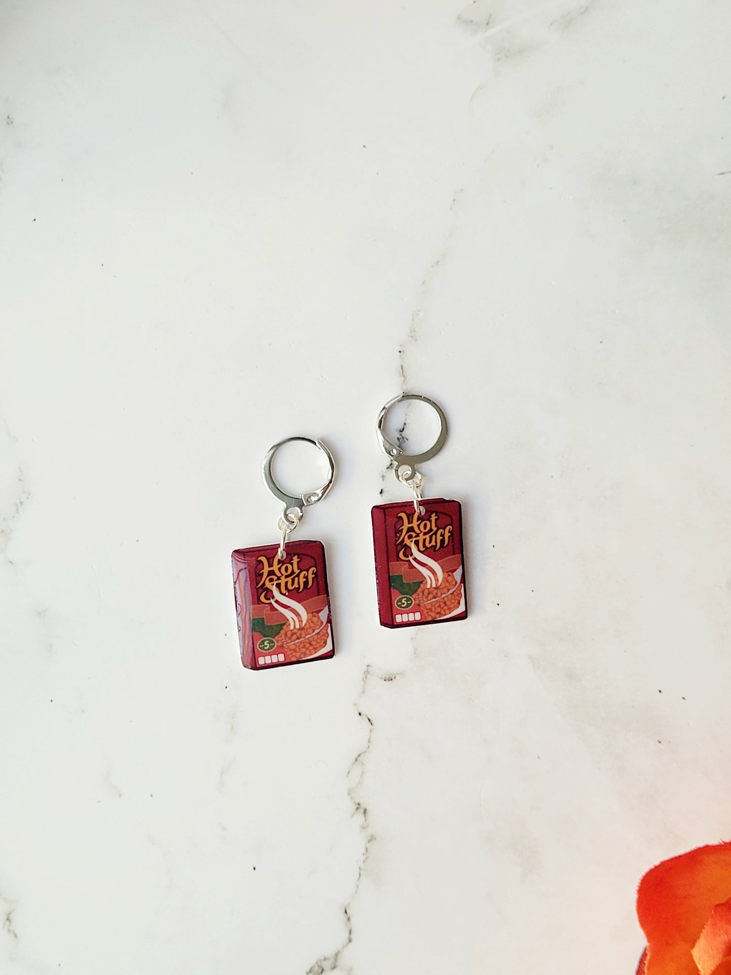 Cranberry sauce earrings on a marble background with fall foliage.