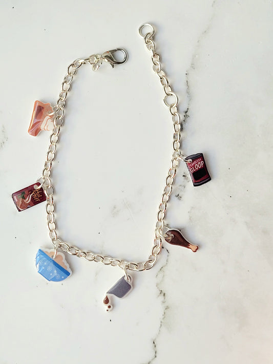 close up of silver charm bracelet with thanksgiving themed charms on a marble background.