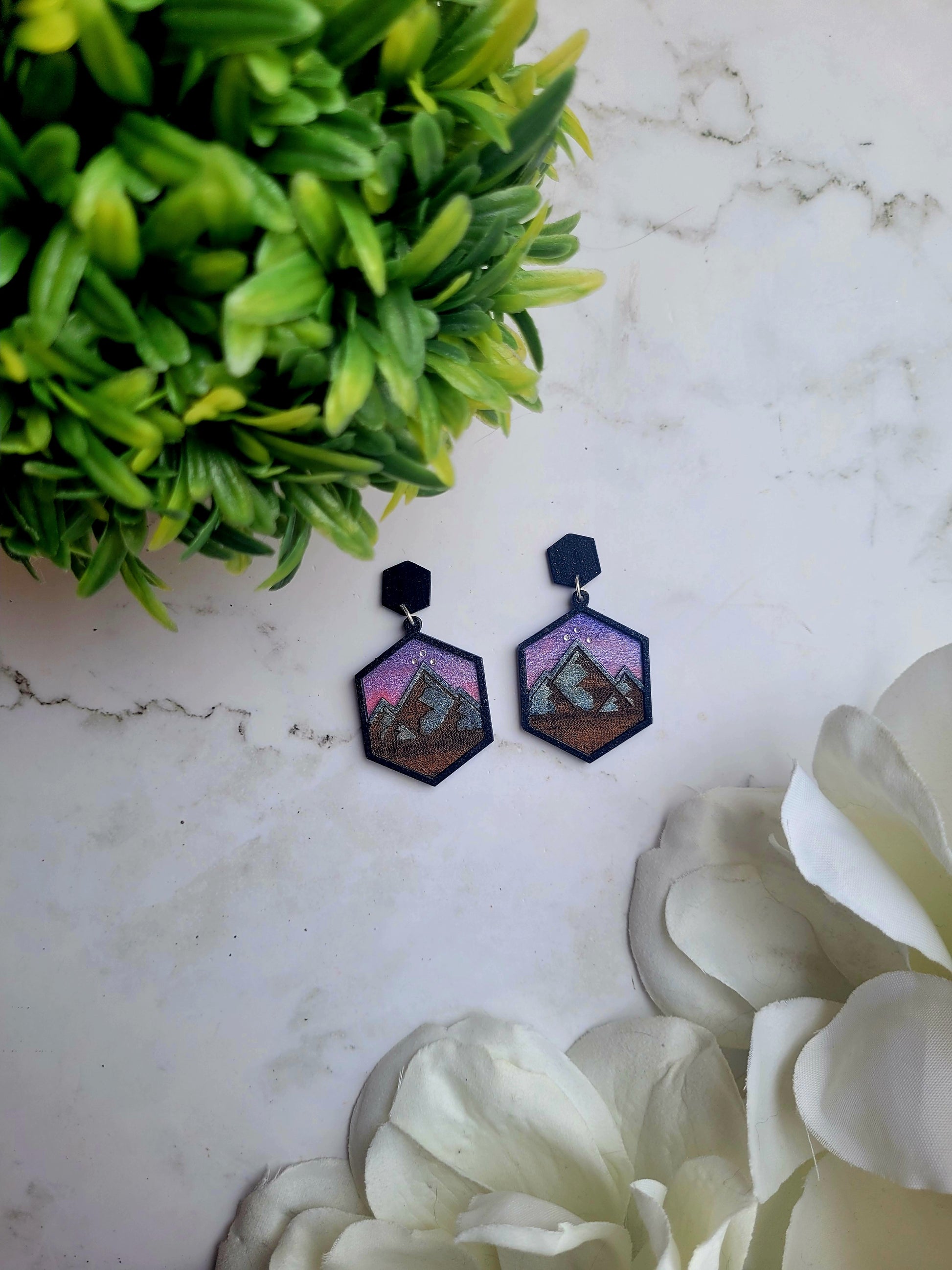 Night Court Earring on a marble background surrounded by foliage