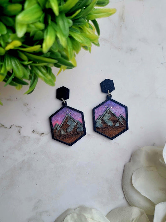 Close up of night court earring on a marble background surrounded by foliage