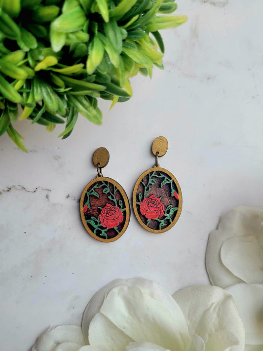 close up of Spring Court Earrings on a marble background surrounded by foliage