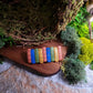 Bookstack barrette on a wood and stone background surrounded by moss