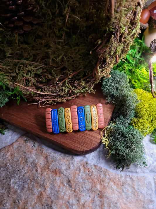 Bookstack barrette on a wood and stone background surrounded by moss