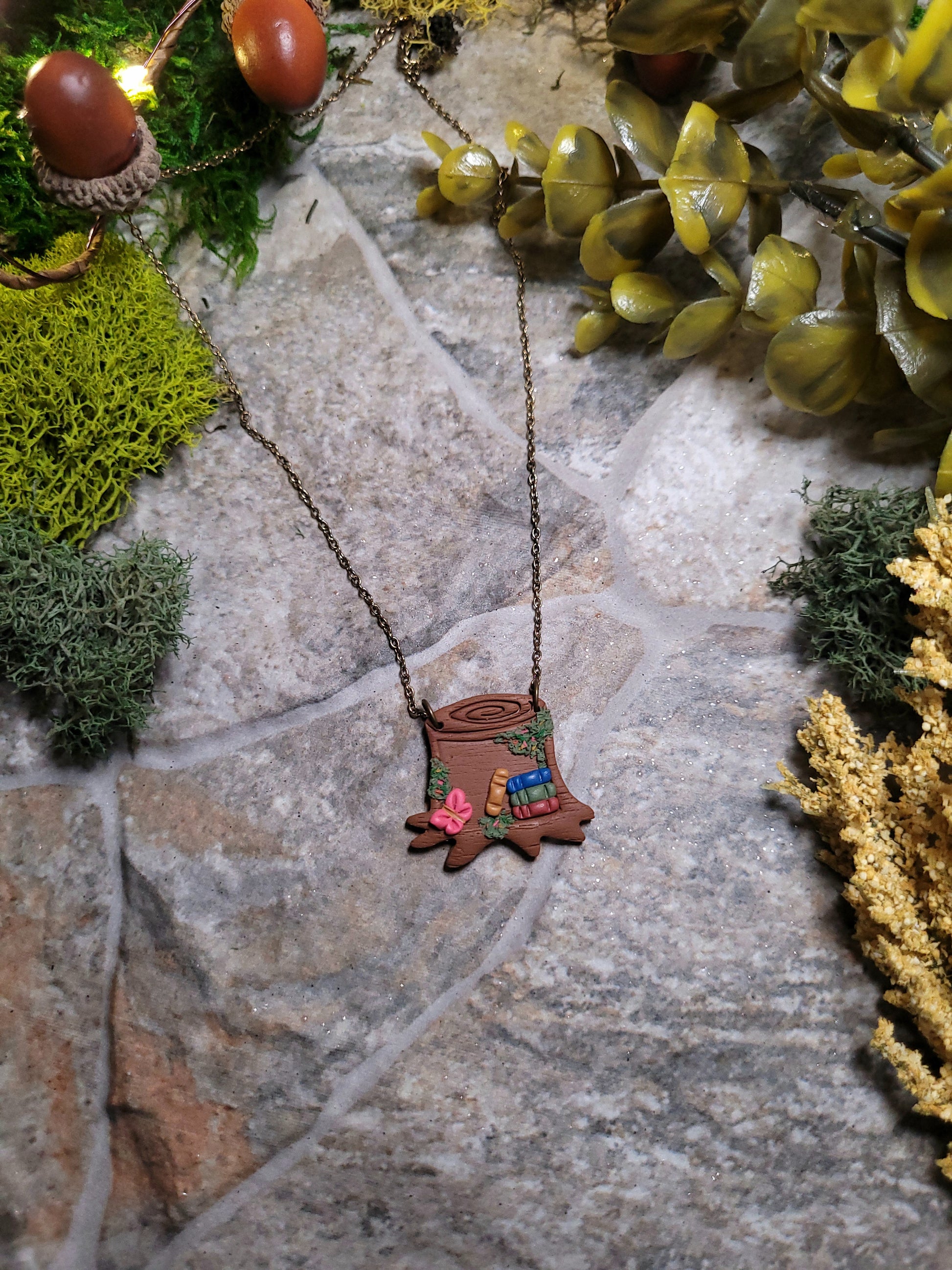 Stump Shelf necklace on a stone background surrounded by foliage 