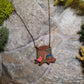 close up of Stump Shelf necklace on a stone background surrounded by foliage 