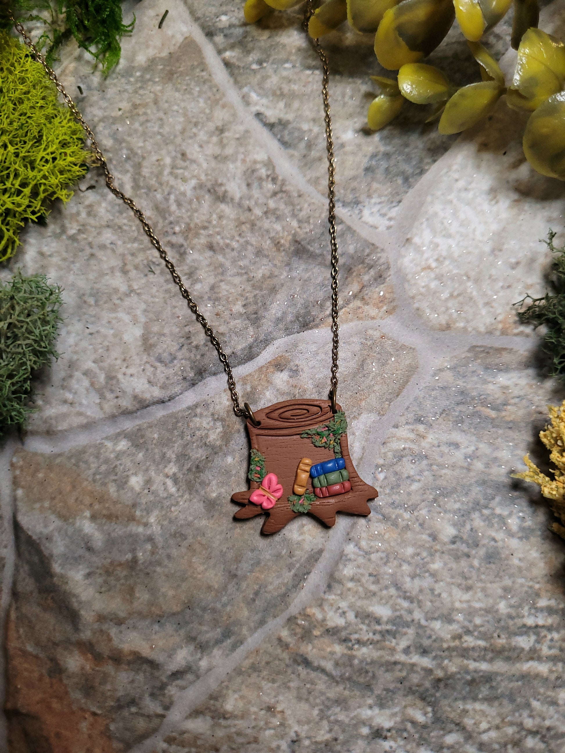 close up of Stump Shelf necklace on a stone background surrounded by foliage 