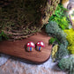 Close up of toadstool studs on wood and stone background surrounded by moss. 