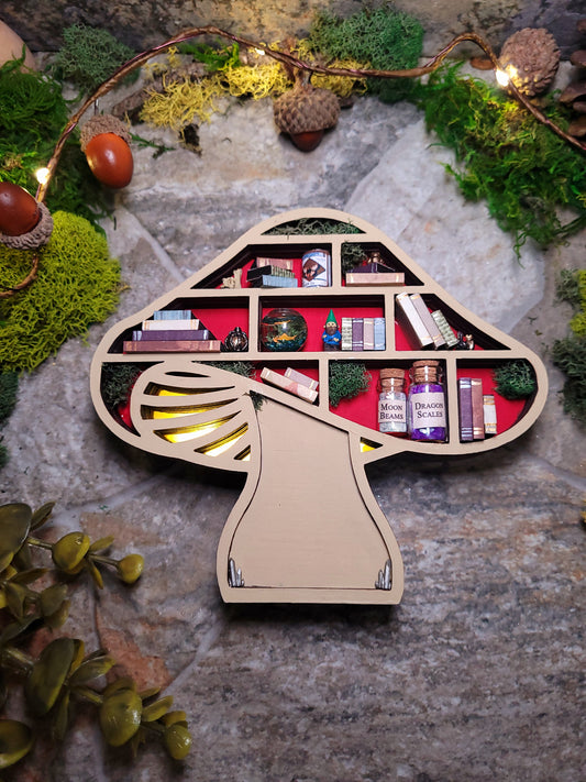 Lit Mushroom Mini Bookshelf on a stone background surrounded by foliage. 