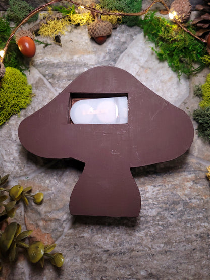 Back of Mushroom Mini Bookshelf on a stone background surrounded by foliage. 