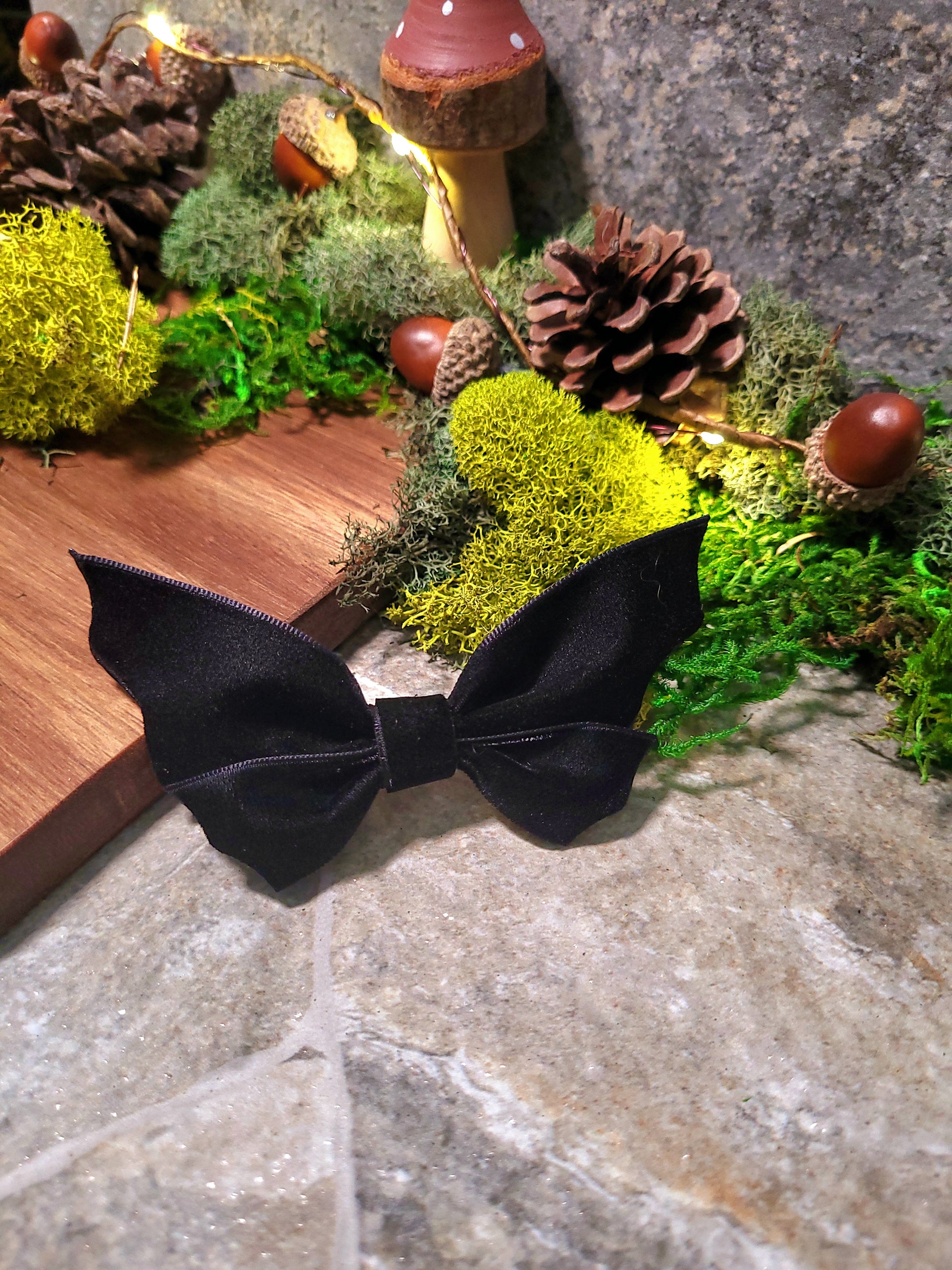 Bat bow propped against wood on stone background surrounded by foliage 