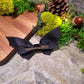 Back of bat bow on wood and stone background surrounded by foliage 