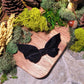 Bat bow on wood and stone background surrounded by foliage 