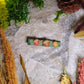 Right opening acorn clips on a stone background surrounded by foliage