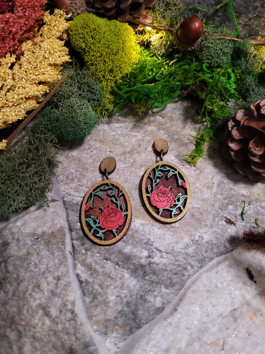 Spring Court Earrings on a stone background surrounded by foliage