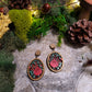 close up of Spring Court Earrings on a stone background surrounded by foliage