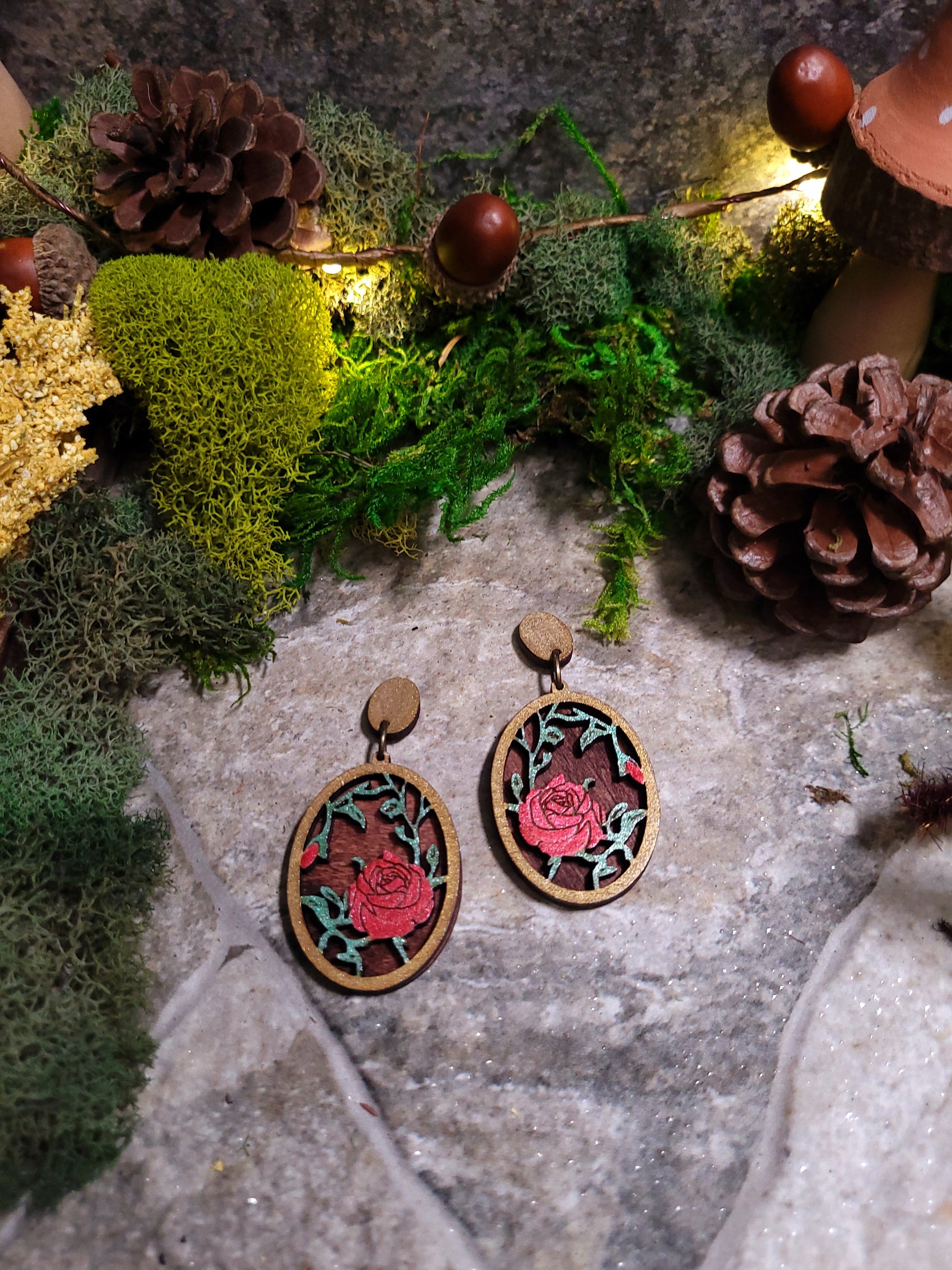 close up of Spring Court Earrings on a stone background surrounded by foliage