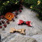 Christmas Bow Barrettes on a  stone background surrounded by foliage