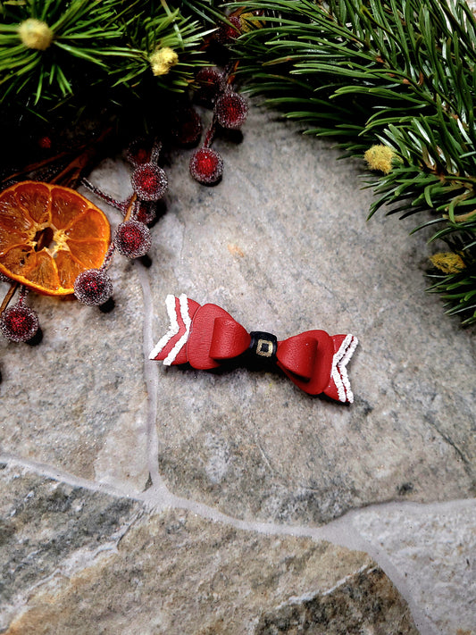 Santa Bow Barrettes on a  stone background surrounded by foliage