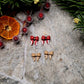 Christmas Bow studs on a stone background surrounded by foliage