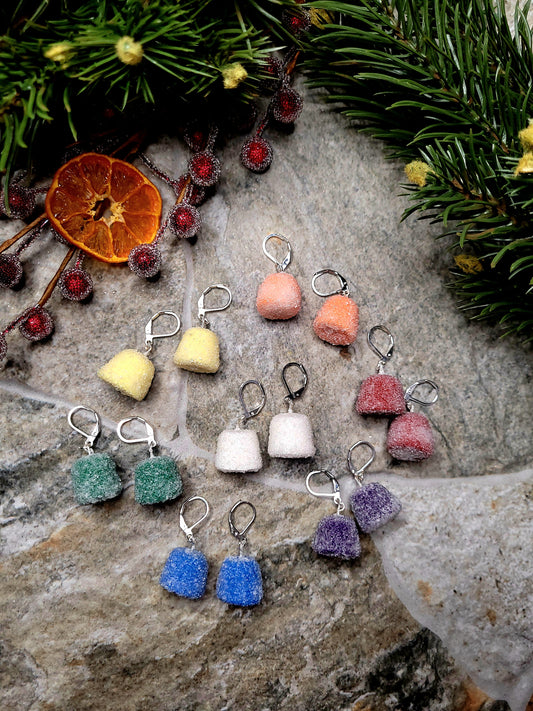 Rainbow Gumdrop earrings on a  stone background surrounded by foliage