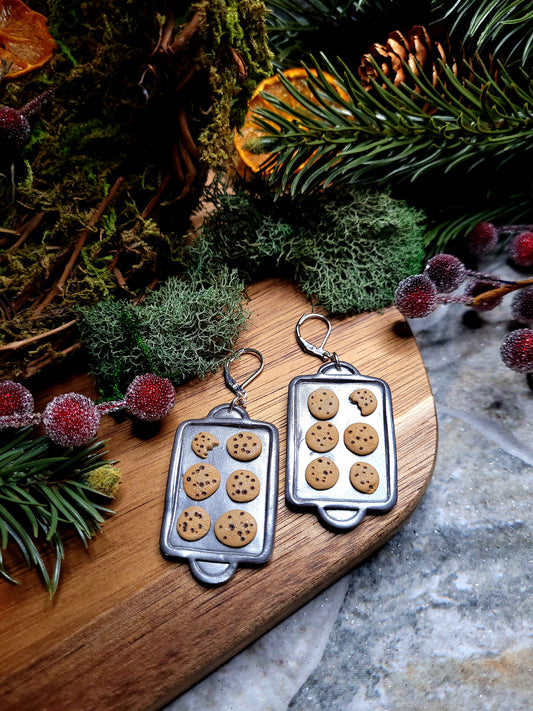 Cookie Tray earrings on a  wood and stone background surrounded by foliage