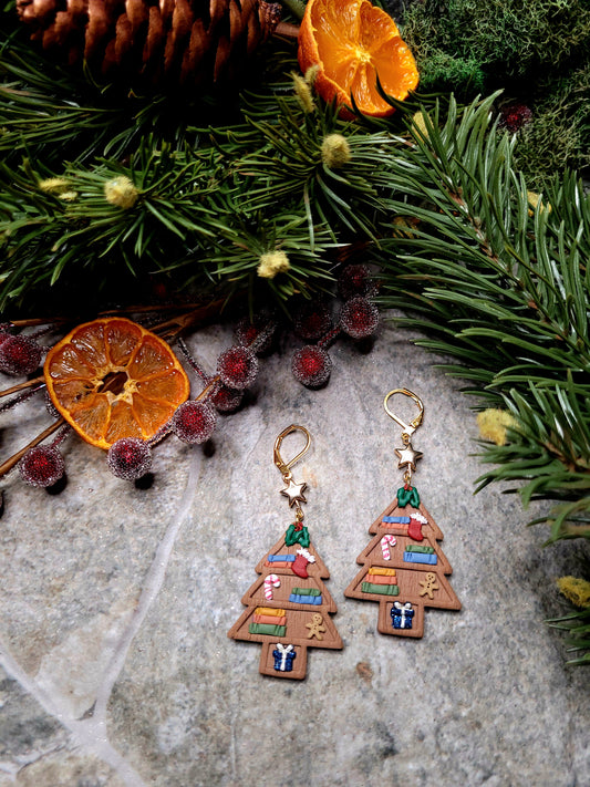 Christmas Tree Shelf Earring on a stone background surrounded by foliage. 