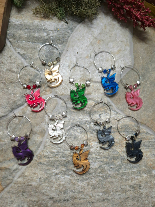 Set of colorful wine charms with dragon designs on a stone surface