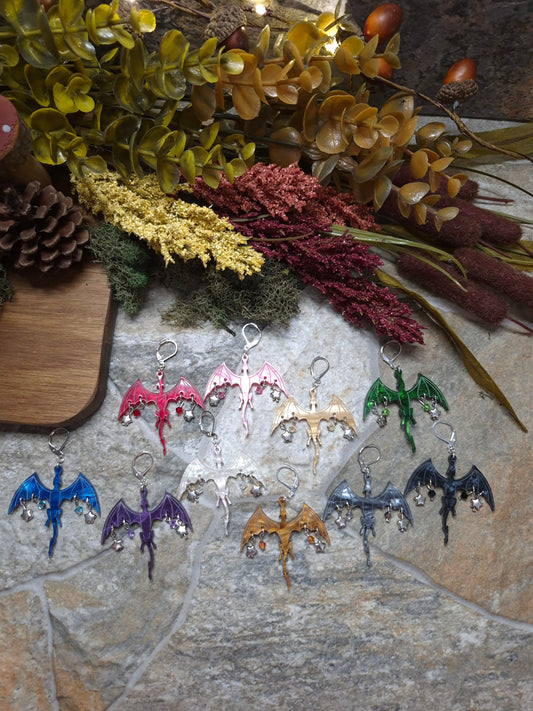 10 colors of dragon dangles on a stone background surrounded by foliage. 