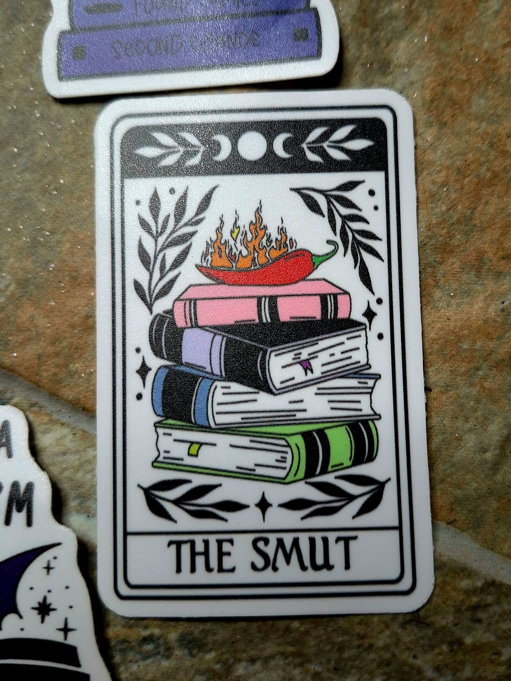 The Smut tarot sticker on a stone background. 
