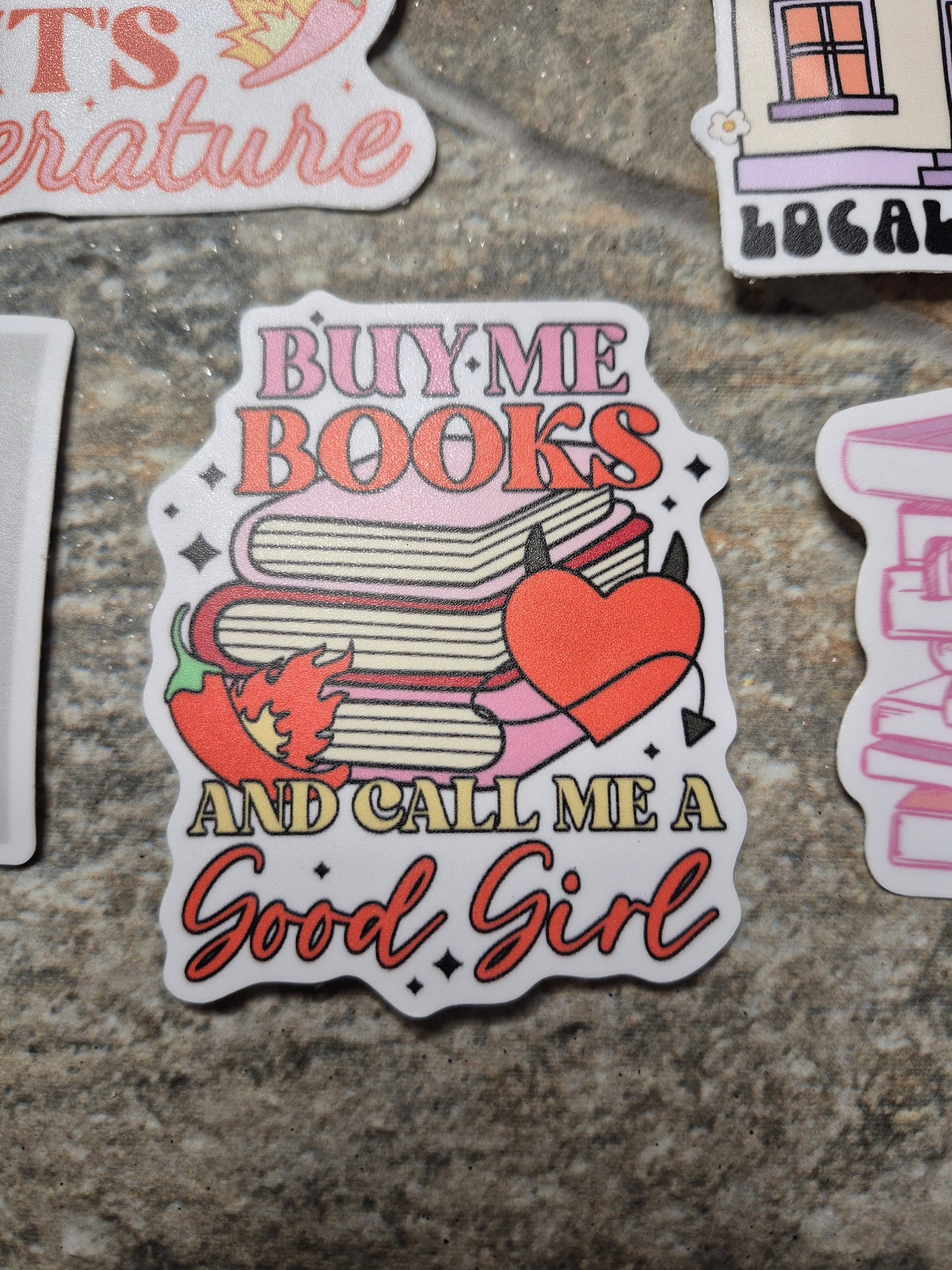 buy me books sticker on stone background 