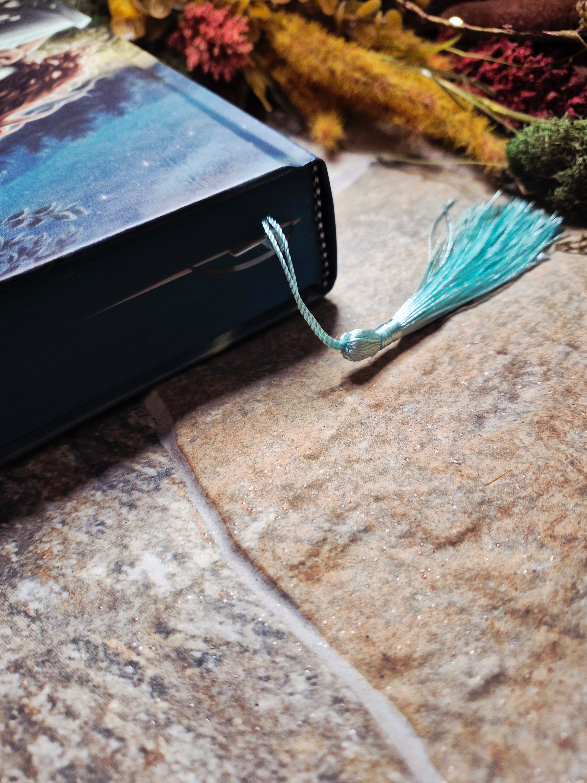 closed book with a tassel sticking out on a stone background. 

